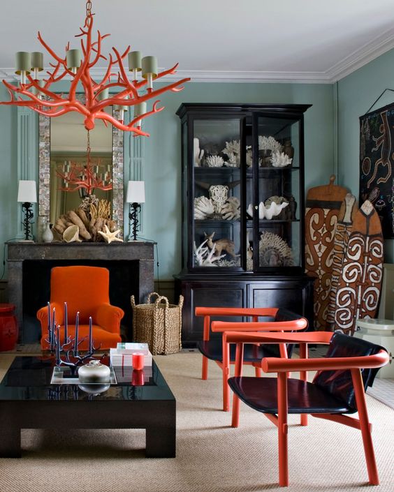 un lampadario arancione di ispirazione corallo che riecheggia con le sedie nella stanza aiuta a sentire come il mare