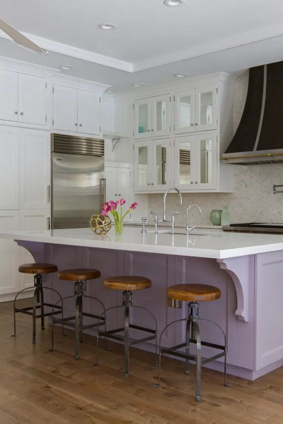 una cucina vintage neutra con isola cucina lilla, ripiani bianchi, alzatina piastrellata bianca e sgabelli in legno