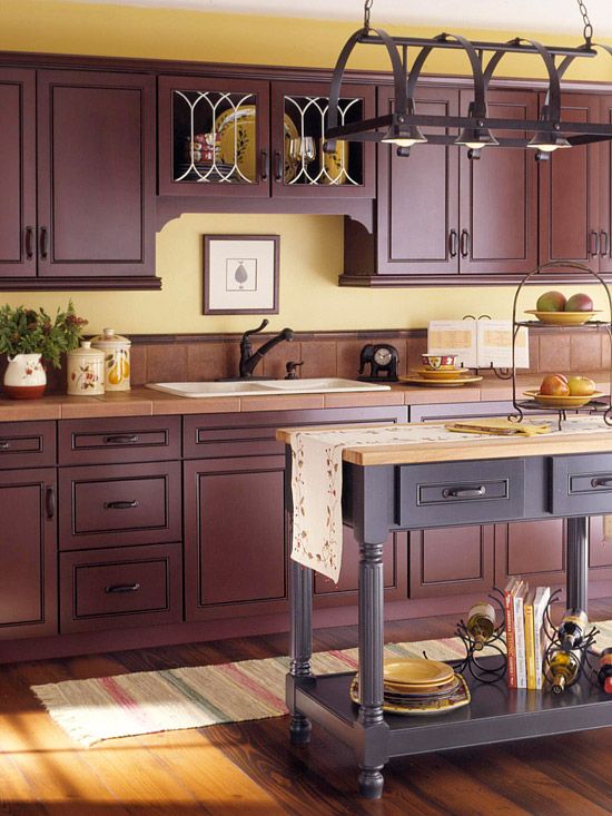 un'elegante cucina melanzana con ripiani in piastrelle di terracotta e un'isola cucina viola abbinata con un piano di lavoro in legno chiaro