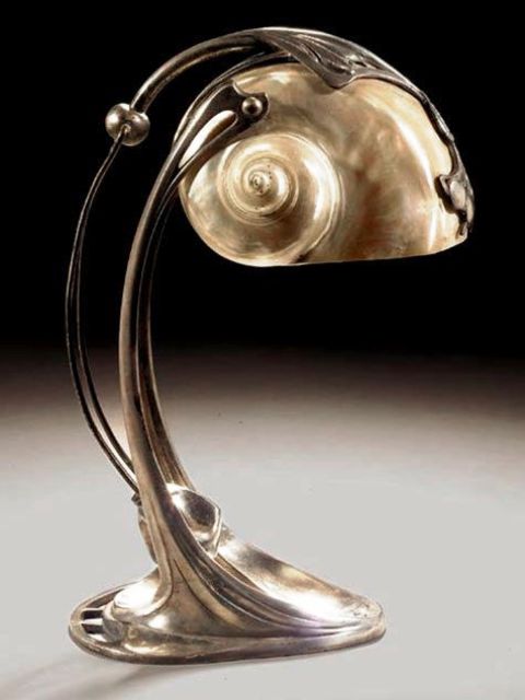 una bellissima lampada da tavolo in metallo e conchiglie ha un aspetto accattivante, audace e deciso e ricorda il mare allo stesso tempo
