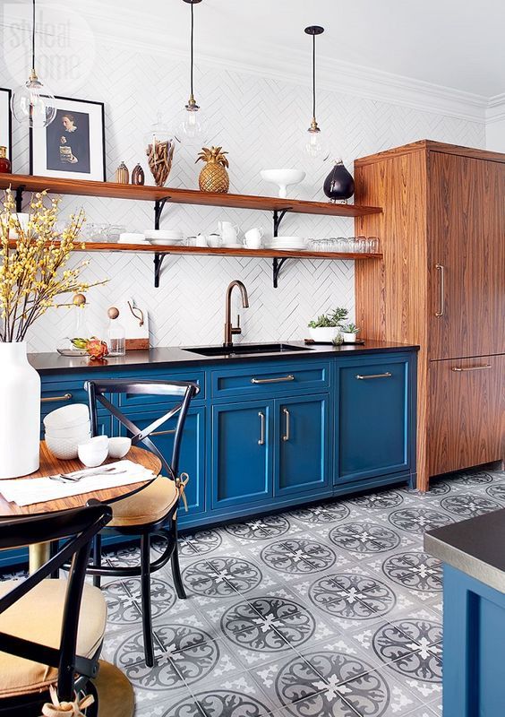 è accogliente una cucina blu audace con pavimento in piastrelle stampate, mensole in legno e un mobile contenitore, sedie nere con cuscini