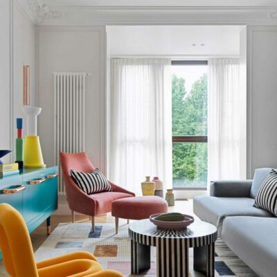 Il soggiorno presenta mobili e oggetti colorati, accenti a righe e accessori audaci