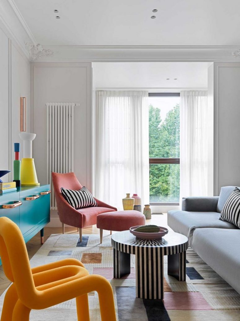 Il soggiorno presenta mobili e oggetti colorati, accenti a righe e accessori audaci