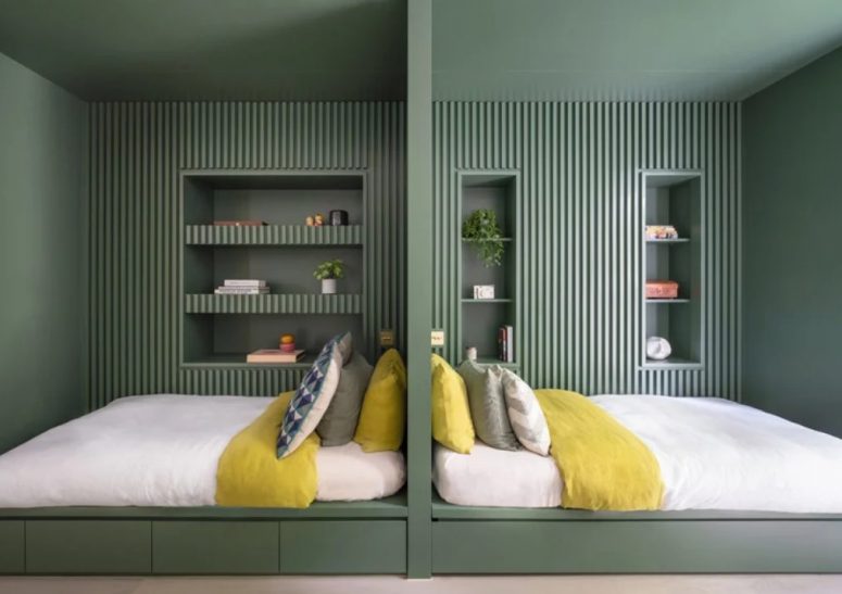 Ecco una tranquilla camera da letto matrimoniale arredata nel verde, con lastre di legno e nicchie per riporre le cose
