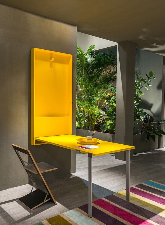 una scrivania pieghevole o un tavolo da pranzo in giallo sole possono essere nascosti in qualsiasi momento e anche la sedia è pieghevole