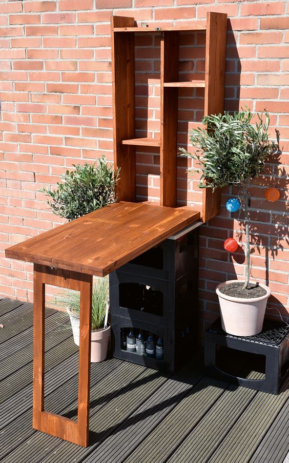 un tavolo Murphy per esterni può essere utilizzato come bar o ripostiglio, decorarlo con del verde in vaso