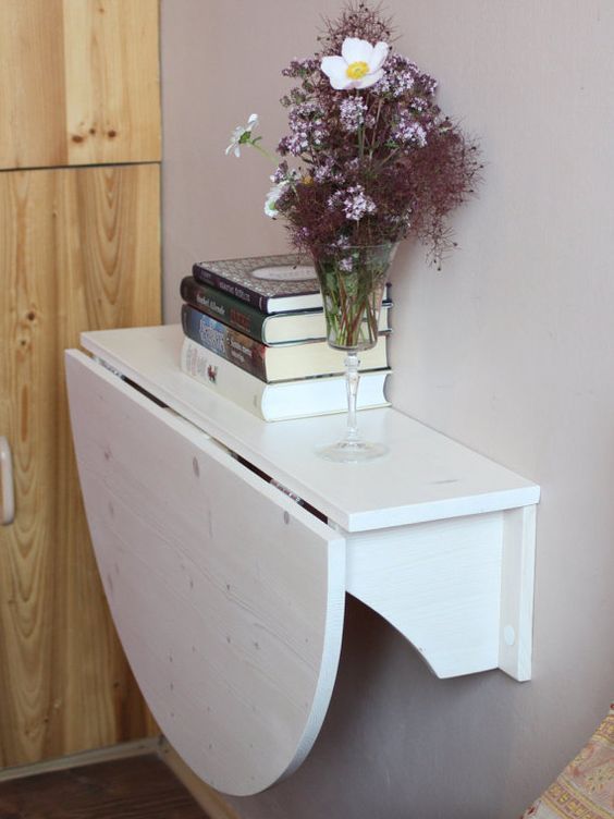 una scrivania bianca pieghevole a parete o un tavolo per la colazione è un ottimo modo per risparmiare spazio