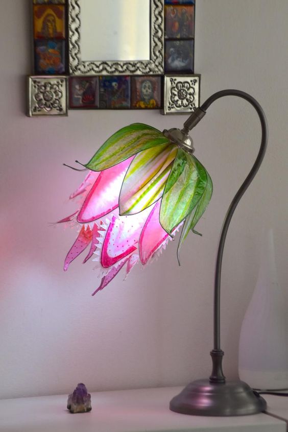 una lampada da tavolo colorata che mette in mostra un fiore predatore in rosa caldo e verde è un'idea fresca e luminosa