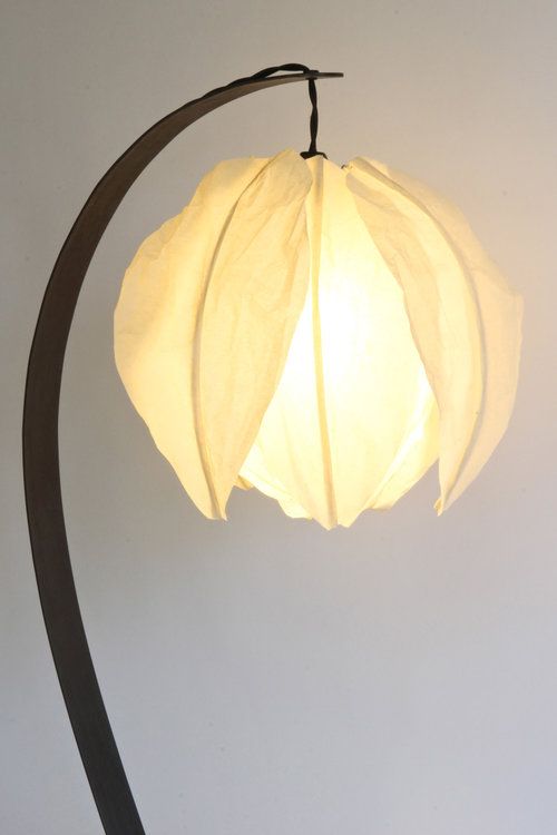 una lampada da tavolo curva con un paralume a forma di fiore sembra molto carina e molto chic