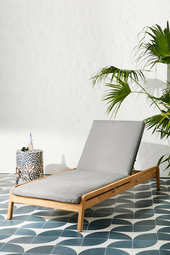 un moderno lettino in legno neutro con rivestimento grigio è un'idea elegante e alla moda per uno spazio esterno moderno