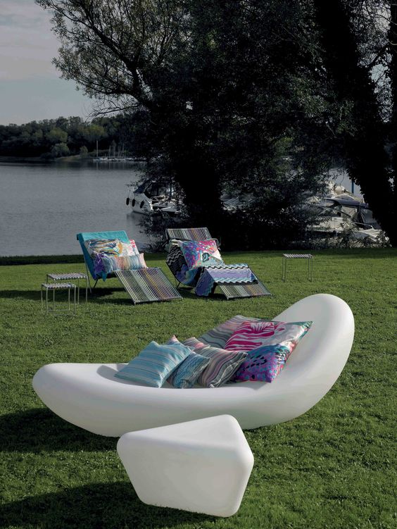 un lettino galleggiante bianco ultramoderno con cuscini luminosi e un tavolino geometrico abbinato per uno spazio moderno