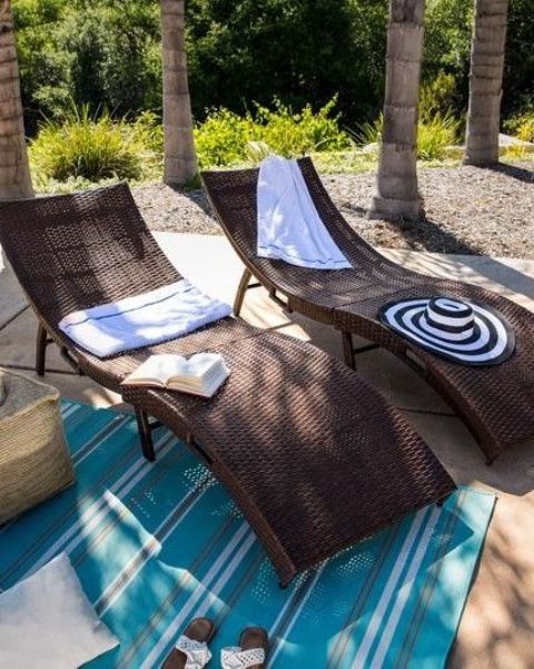 splendidi lettini in vimini curvi scuri con coperte e cuscini sono perfetti per spazi tropicali, rustici e moderni