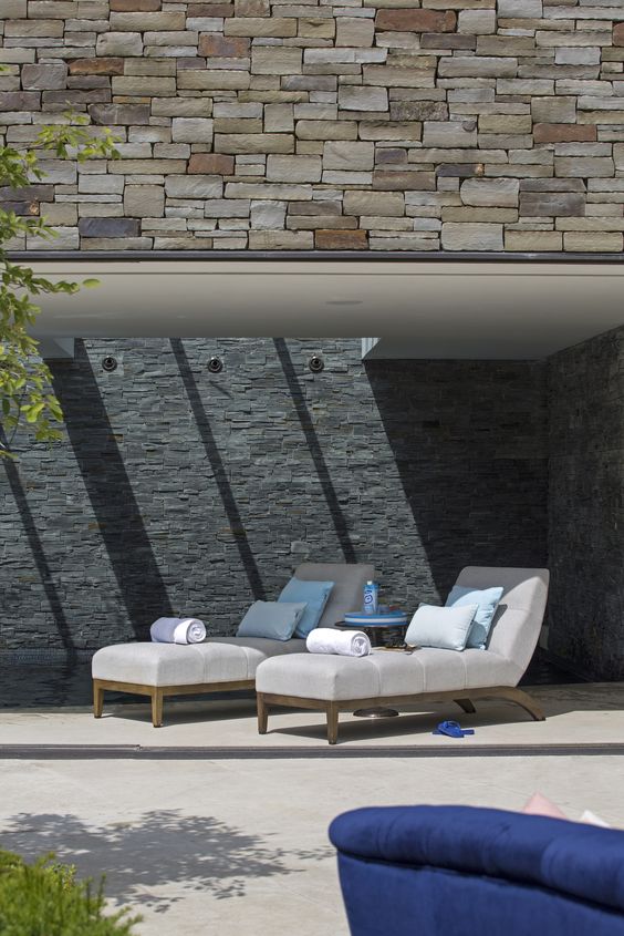 lettini ultra comodi con struttura in legno, tappezzeria neutra e cuscini blu per uno spazio moderno