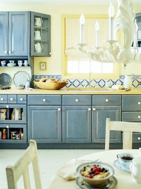 una cucina shabby chic con armadi blu shabby, un backsplash giallo chiaro e tessere di mosaico luminose per un look audace
