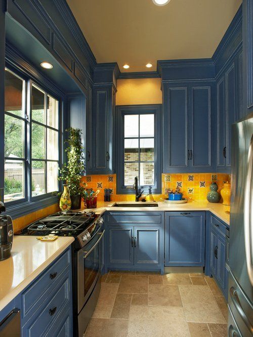 una cucina vintage blu e giallo brillante con alzatina in mosaico e luci incorporate sembra chic ed elegante
