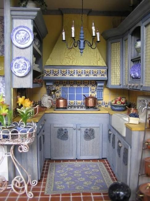 una cucina vintage con armadi azzurri, superfici gialle brillanti e tessere di mosaico e piatti con giallo e blu
