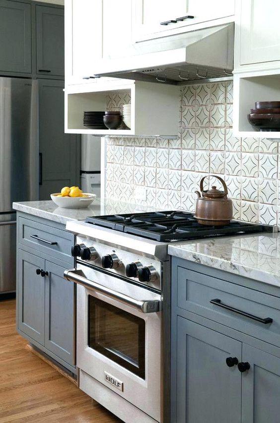 un'elegante cucina blu e bianca con un piano di lavoro grigio e un alzatina in tiel grigio sembra pulita, elegante e senza tempo