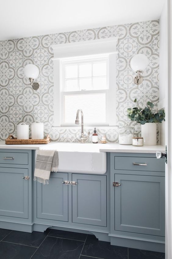 una cucina azzurra con alzatina in mosaico grigio e maniglie metalliche è una bella idea con un tocco tradizionale