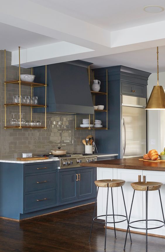 un'elegante cucina vintage blu con un backsplash in piastrelle grigie della metropolitana e tocchi d'oro e legno naturale qua e là