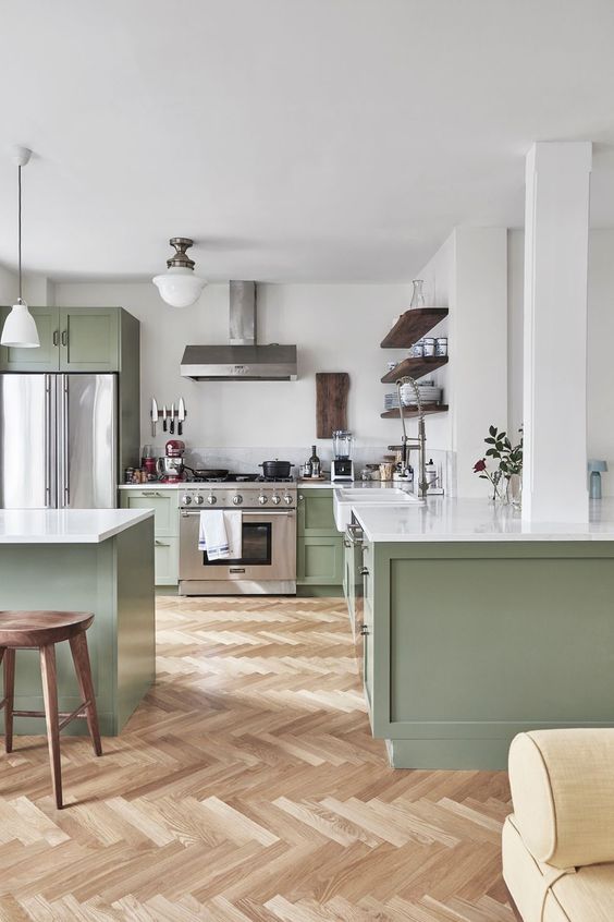 una cucina contemporanea chic in verde chiaro e bianco, con tocchi di legno scuro e ripiani bianchi è molto accogliente