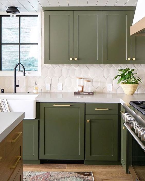 una cucina verde accattivante con un backsplash di piastrelle bianche e tocchi d'oro più infissi neri è super elegante