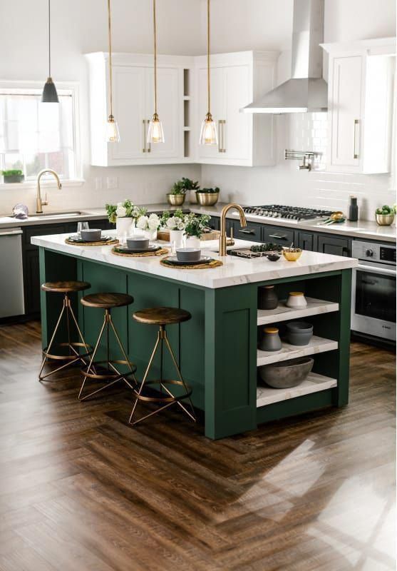 un'elegante cucina verde scuro e bianca con tocchi in ottone e sgabelli scuri più ripiani in marmo per un look audace