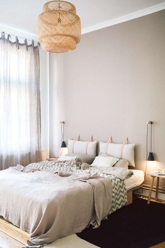 una camera da letto contemporanea con una testiera del cuscino sospesa che ammorbidisce e rende lo spazio più accogliente