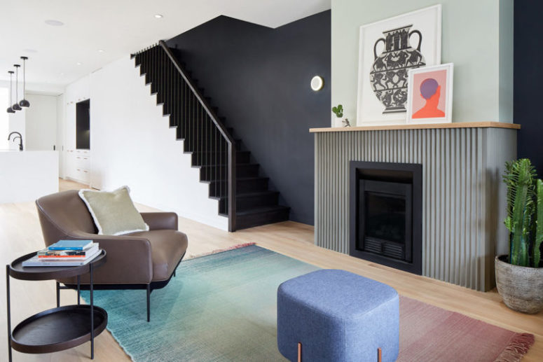 Il soggiorno è rappresentato con un caminetto grigio, comodi mobili in stile metà del secolo e un tappeto sfumato