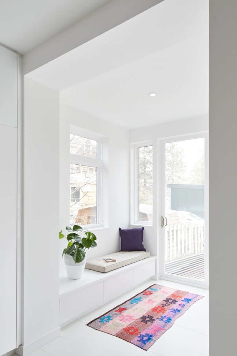 Una piccola veranda con un angolo lettura, cassetti portaoggetti è fatto con molte finestre per far entrare la luce