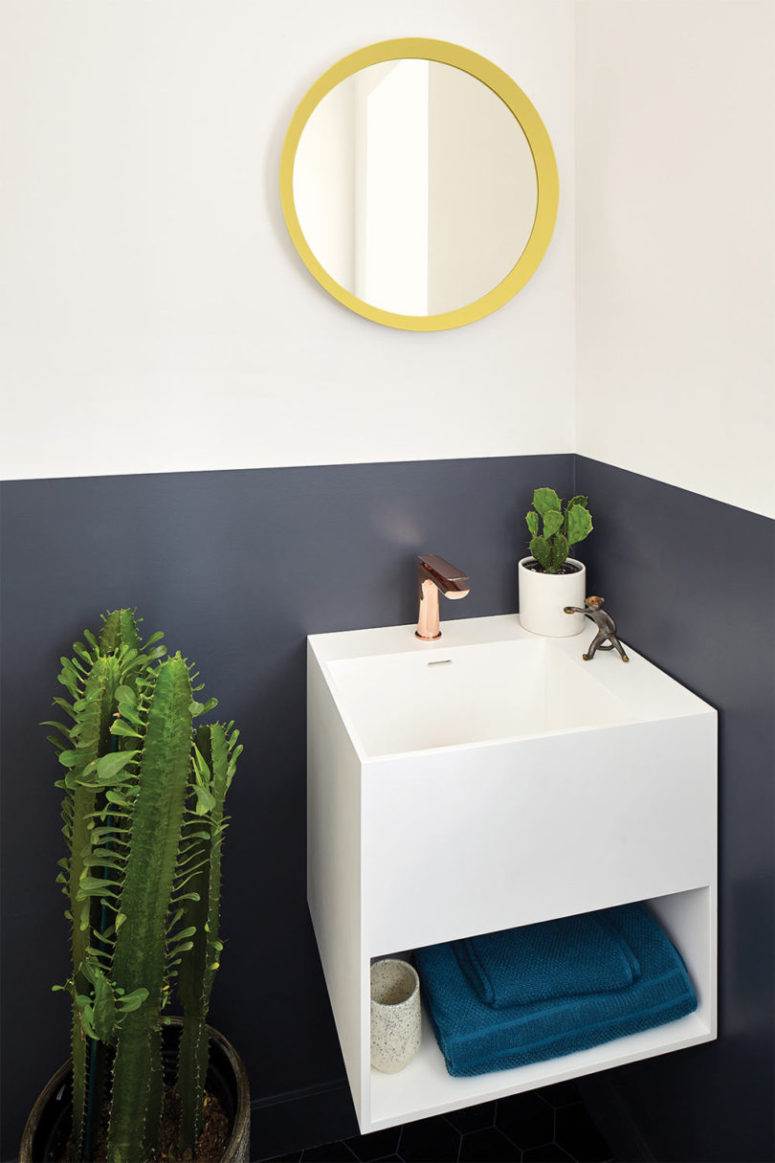 La toilette è dotata di blocchi di colore, cactus in vaso e un lavandino galleggiante con ripostiglio