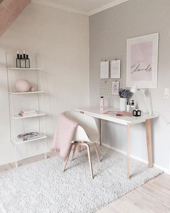 un ufficio domestico femminile con tocchi di blush e scaffale a parete che è delicato e arioso