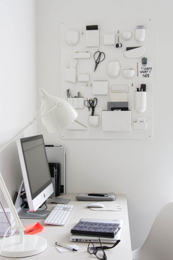 un creativo organizer da parete bianco con vari vasi, supporti e contenitori per tutte le cose da ufficio