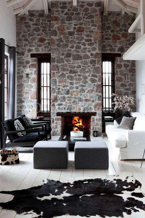 uno spazio monocromatico contemporaneo con pareti in pietra luminosa e un camino, mobili in bianco e nero eleganti e laconici
