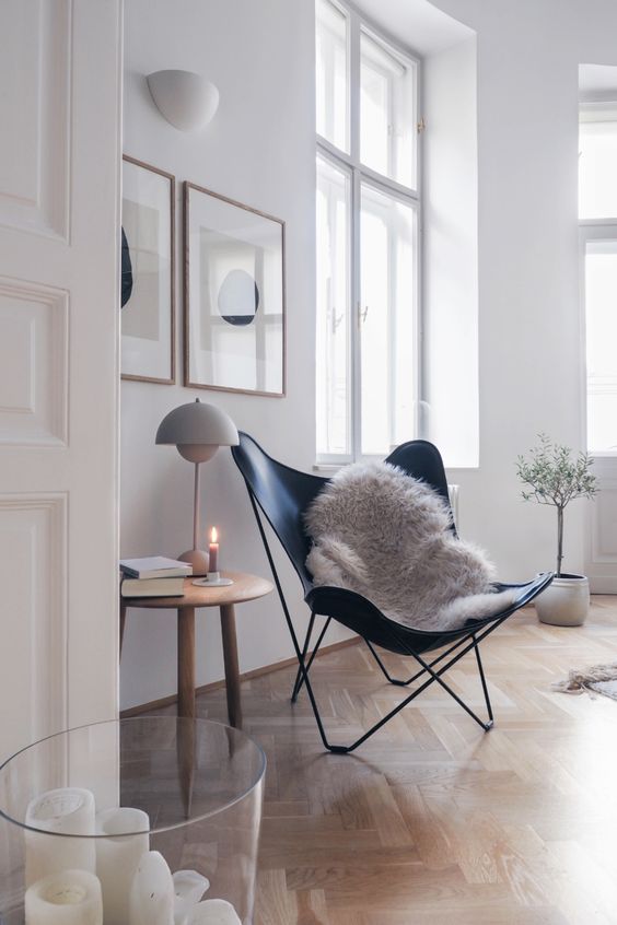 un soggiorno luminoso con pareti bianche e pavimento in parquet chiaro più mobili su gambe