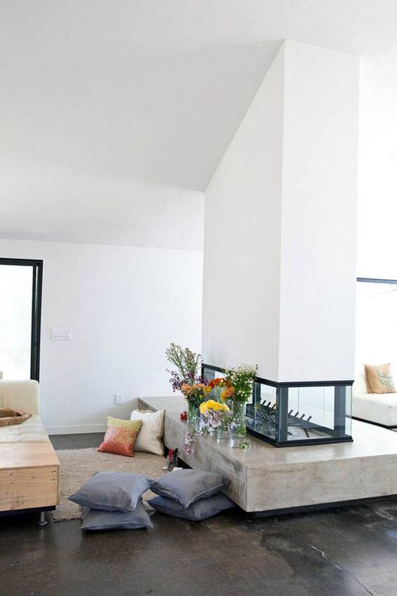 un elegante camino bifacciale bianco con una parte in vetro e una in cemento è un'idea chic per una casa contemporanea