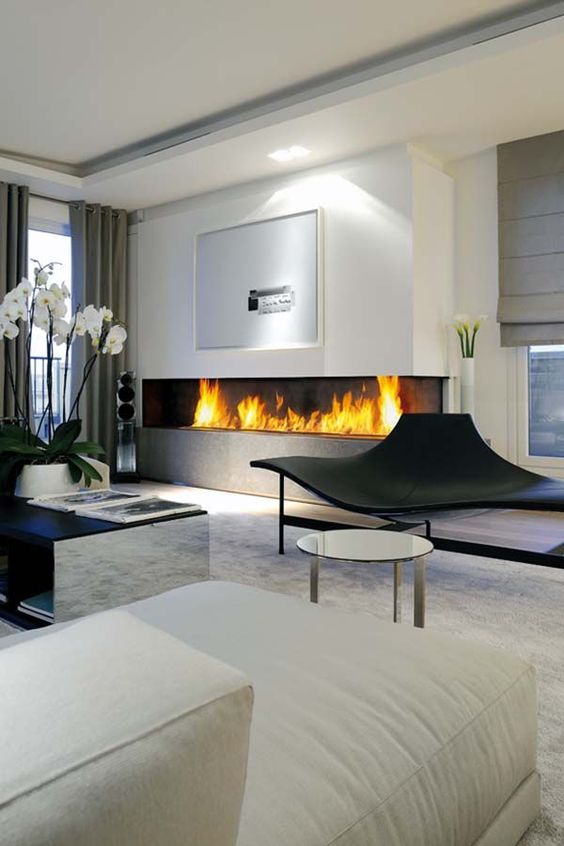 un grande camino a incasso minimalista nel soggiorno è un'idea elegante e audace con un tocco moderno