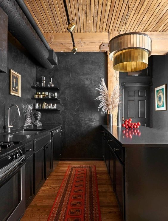 una cucina creativa di ispirazione vintage in nero con un soffitto in legno di colore chiaro e un pavimento in legno dai colori intensi per riscaldare lo spazio