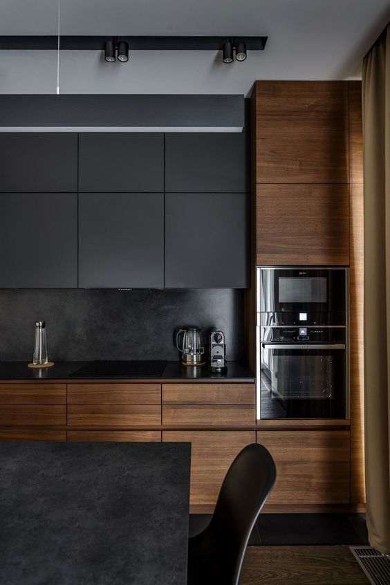 una cucina nera scura con eleganti armadi in legno che la rendono più accogliente e accogliente