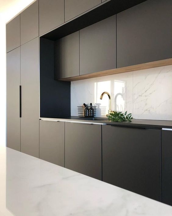 una cucina moderna minimalista in bianco e nero con un alzatina in marmo e un pavimento bianco sembra audace e contrastante