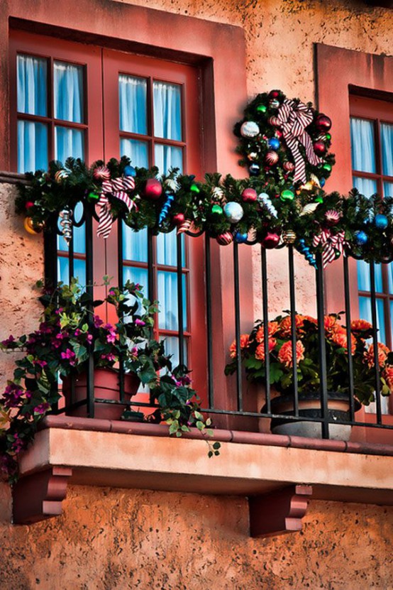 fioriture audaci in vasi e ornamenti e ghirlande e ghirlande verdi per decorare il balcone per le vacanze invernali
