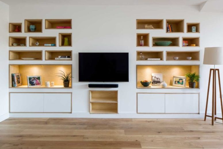 Il soggiorno è fatto con mensole incorporate e una TV a parete