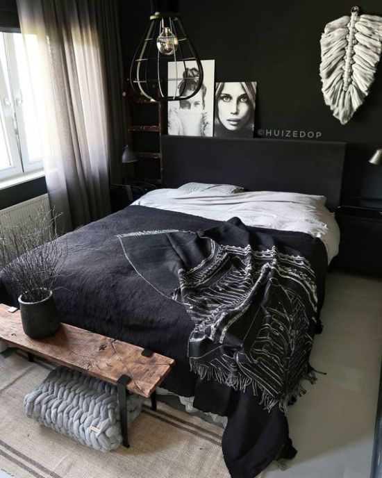 una camera da letto nordica con pareti nere, un set di biancheria da letto chic, opere d'arte e tocchi di bianco