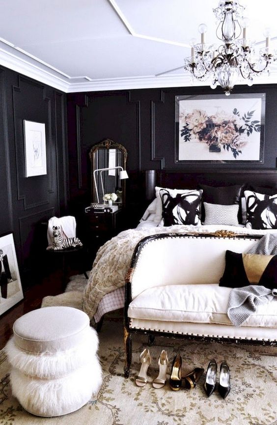 una camera da letto chic con pareti rivestite di pannelli neri è ravvivata da un soffitto bianco e mobili e tocchi cremosi