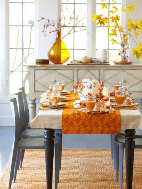 una luminosa sala da pranzo decorata con tocchi di senape e arancio e motivi autunnali, con audaci foglie autunnali, bacche e zucche