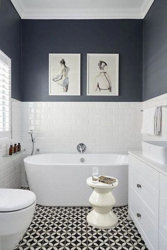 un elegante bagno bianco e nero con un pavimento a mosaico, pareti bianche e nere, una vasca e un lavabo bianco