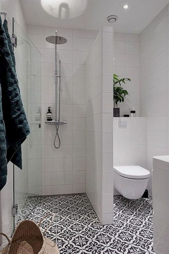 un bagno moderno con tessere di mosaico, piastrelle bianche alle pareti, vegetazione in vaso e un cesto per la conservazione