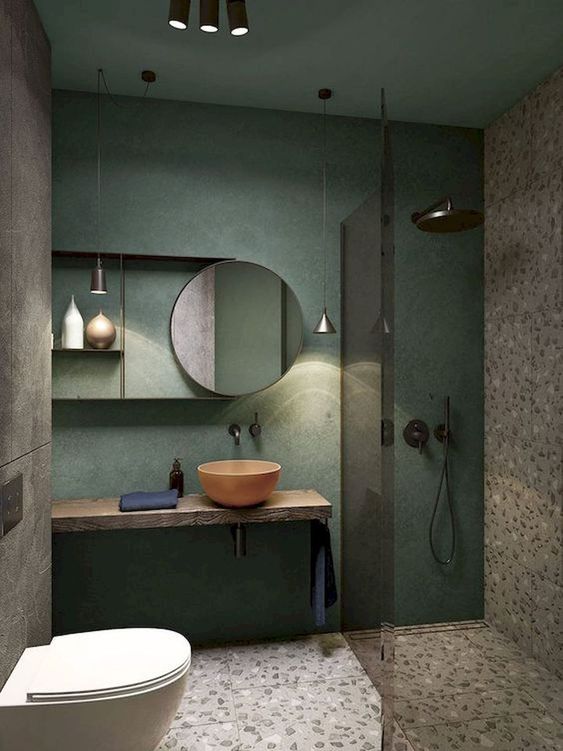 un piccolo bagno creativo con una parete verde, pavimento e parete in terrazzo, un lavabo in legno galleggiante e un lavandino con ciotola di corallo
