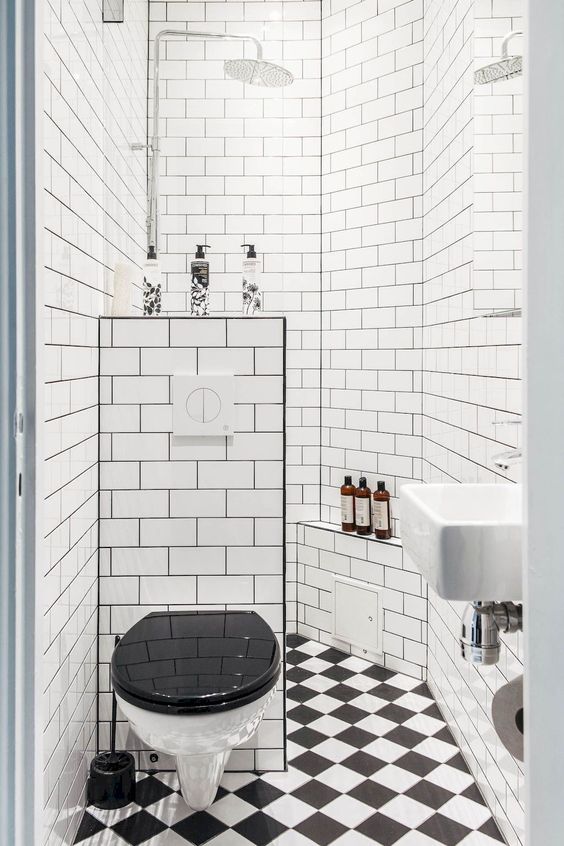 un bagno in bianco e nero di ispirazione retrò con uno spazio doccia, un pavimento di piastrelle a mosaico e una mezza parete