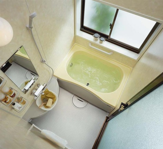 un minuscolo bagno con una vasca da bagno incorporata, un minuscolo lavabo sospeso con un lavandino incorporato e uno specchio