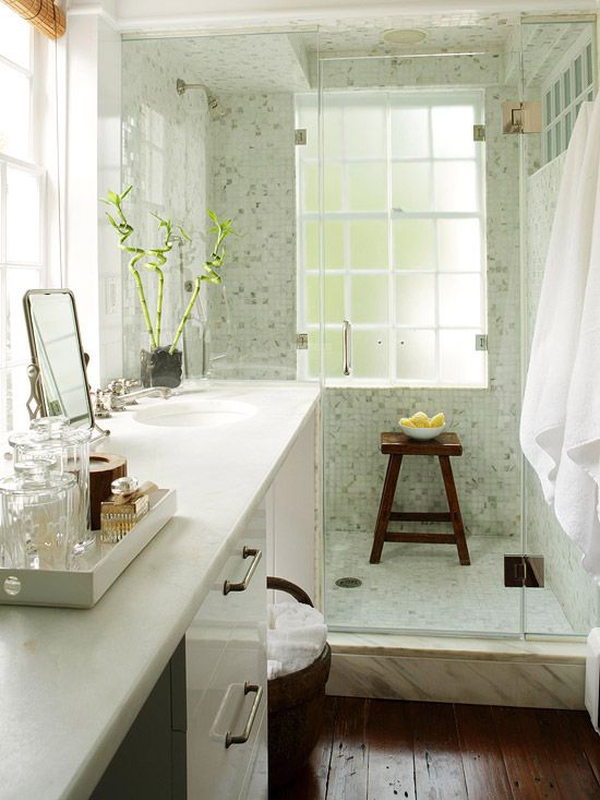 un piccolo bagno accogliente con un grande lavabo e un lavandino incorporato, un pavimento macchiato di scuro, uno spazio doccia verde chiaro